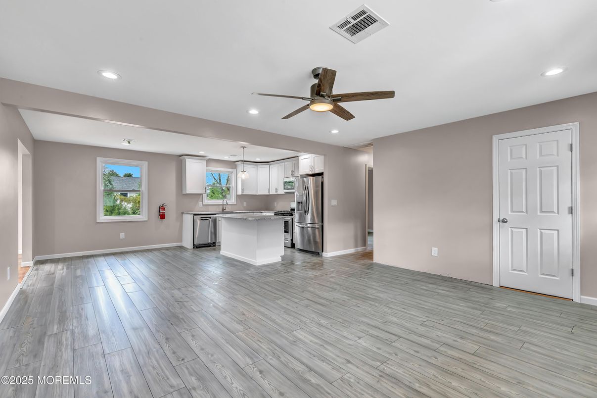 Empty room, Interior, Kitchen, Recessed Lighting, Stainless Steel Appliances, Wood Texture Flooring