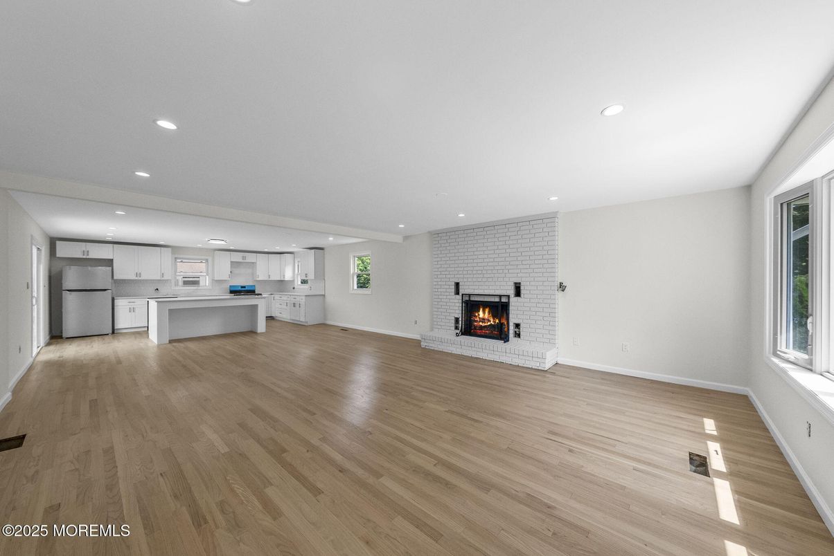 Empty room, Fireplace, Interior, Kitchen, Recessed Lighting, Stainless Steel Appliances, Stone Walls, Wood Texture Flooring