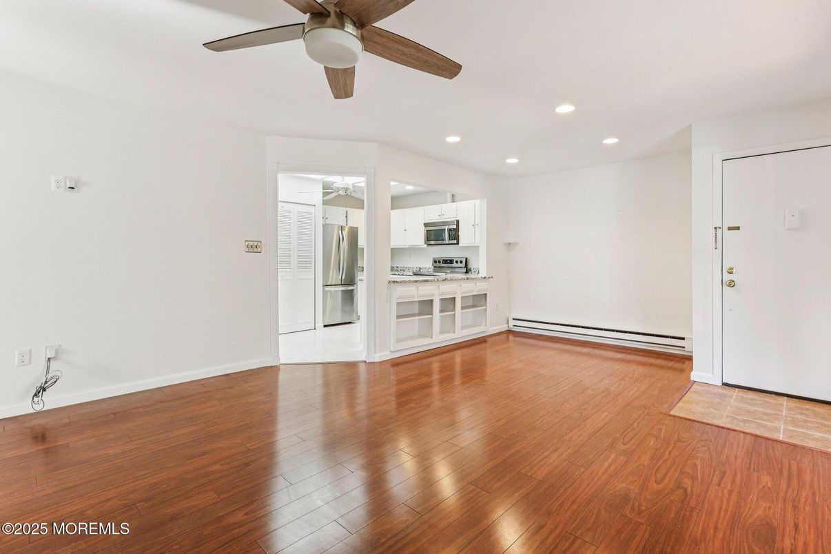 Empty room, Interior, Kitchen, Recessed Lighting, Stainless Steel Appliances, Wood Texture Flooring