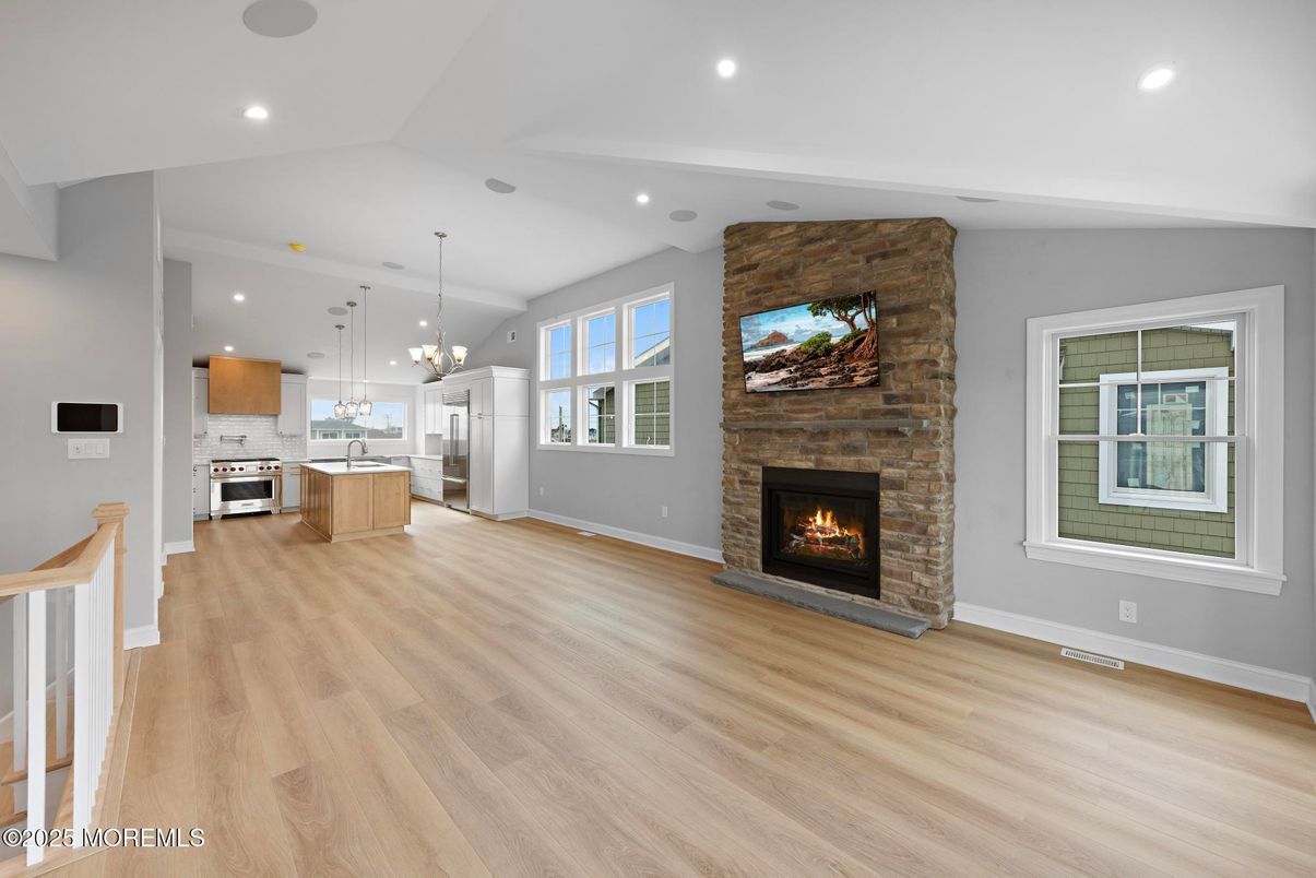 Empty room, Fireplace, Interior, Kitchen, Pendant Lights, Recessed Lighting, Stainless Steel Appliances, Stone Walls, Wood Texture Flooring