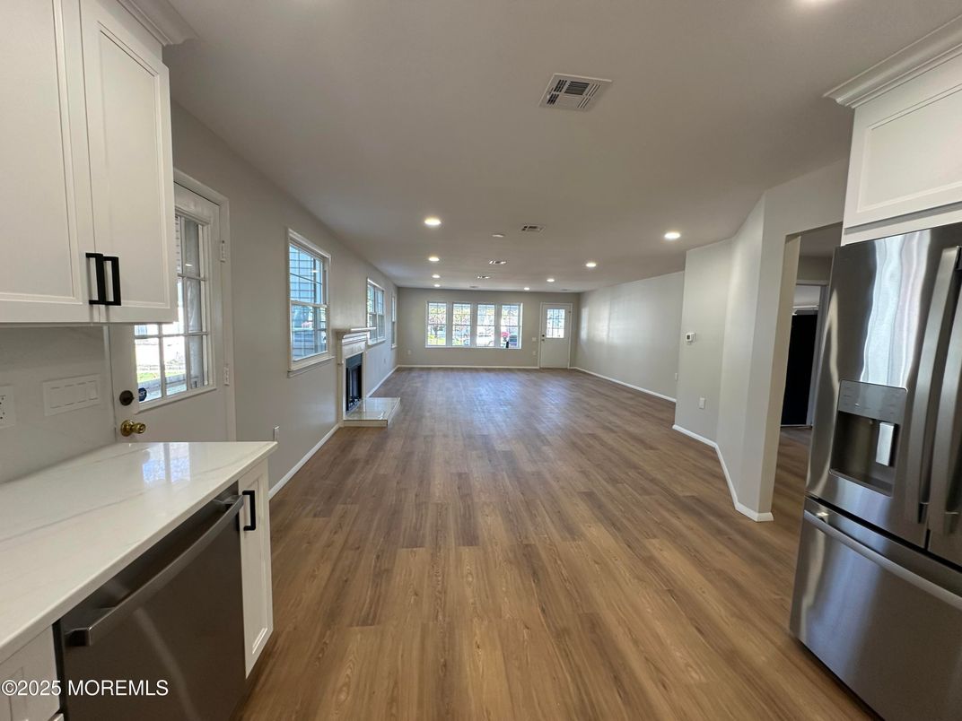 Empty room, Interior, Kitchen, Recessed Lighting, Stainless Steel Appliances, Wood Texture Flooring
