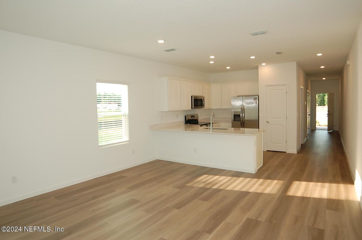 Empty room, Interior, Kitchen, Recessed Lighting, Stainless Steel Appliances, Wood Texture Flooring