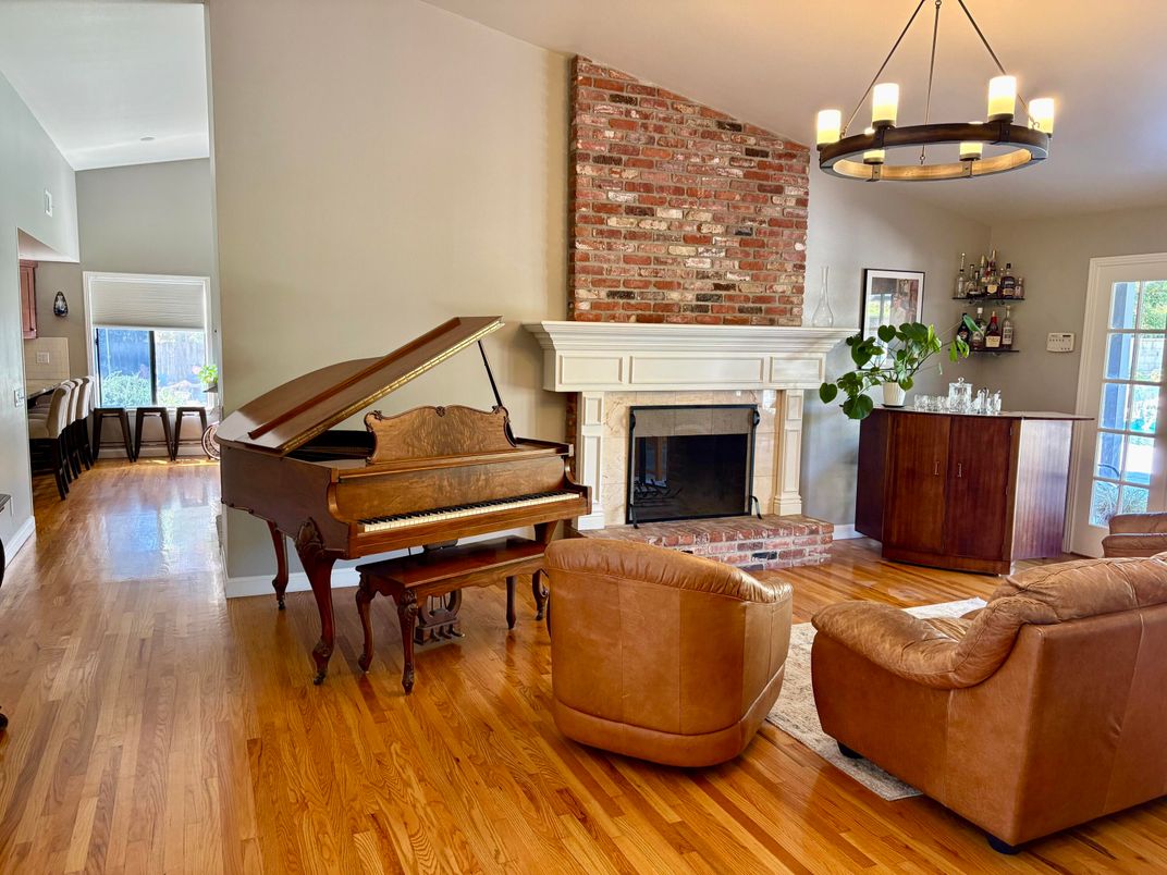 Chandelier, Fireplace, Interior, Living room, Piano, Stone Walls, Wood Texture Flooring