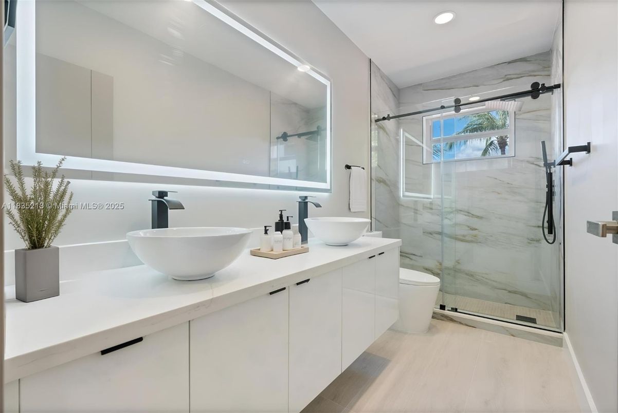 Bathroom, Dual Sink Vanities, Glass Shower, Interior, Marble Walls, Recessed Lighting, Wood Texture Flooring