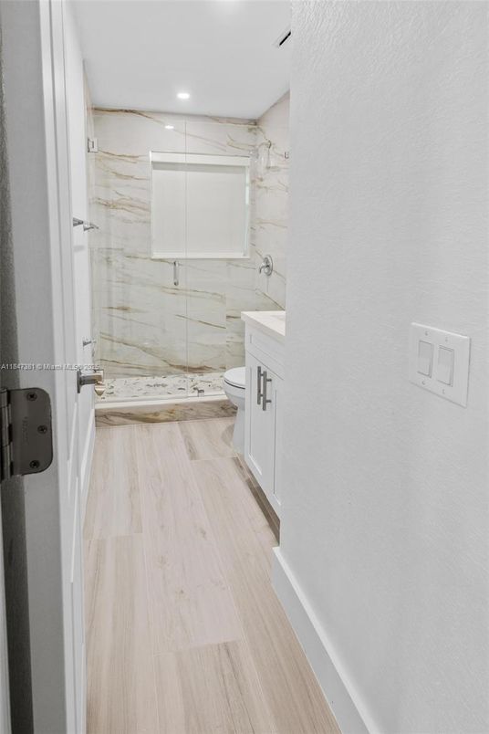 Bathroom, Glass Shower, Interior, Marble Walls, Recessed Lighting, Wood Texture Flooring