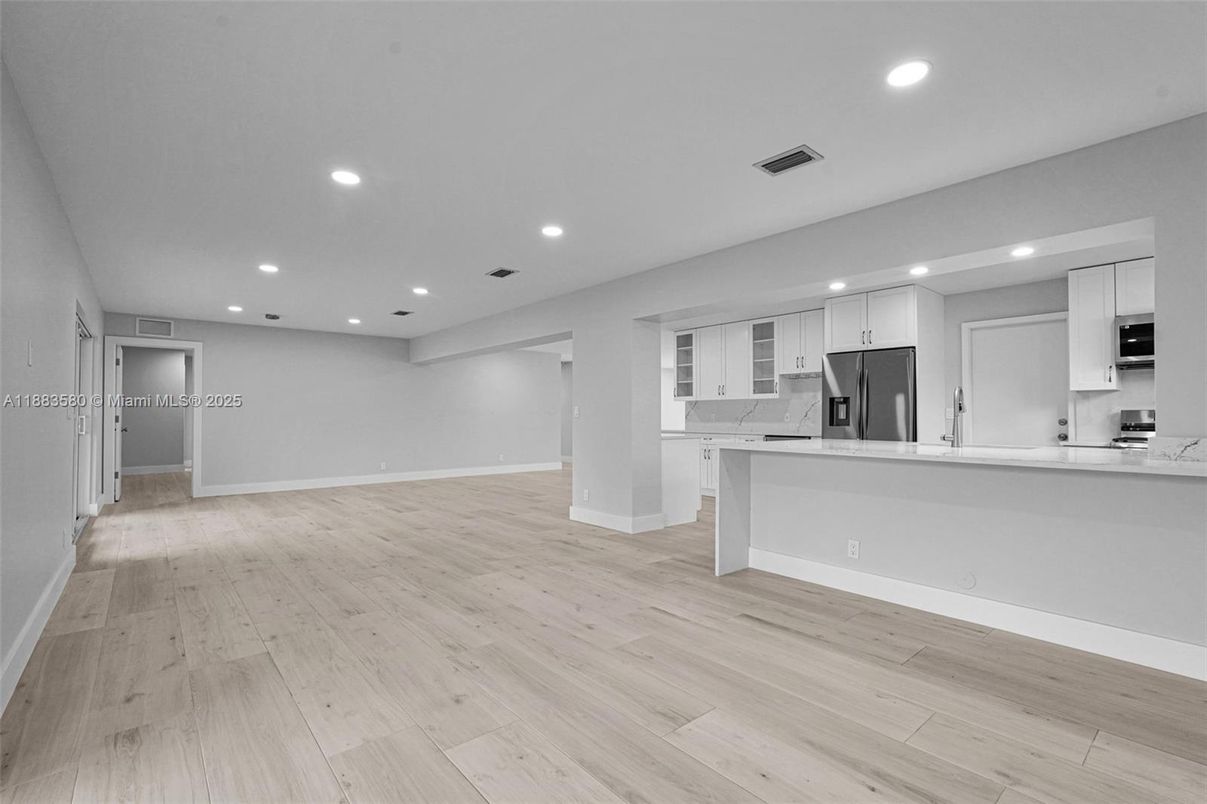 Empty room, Interior, Kitchen, Recessed Lighting, Stainless Steel Appliances, Wood Texture Flooring