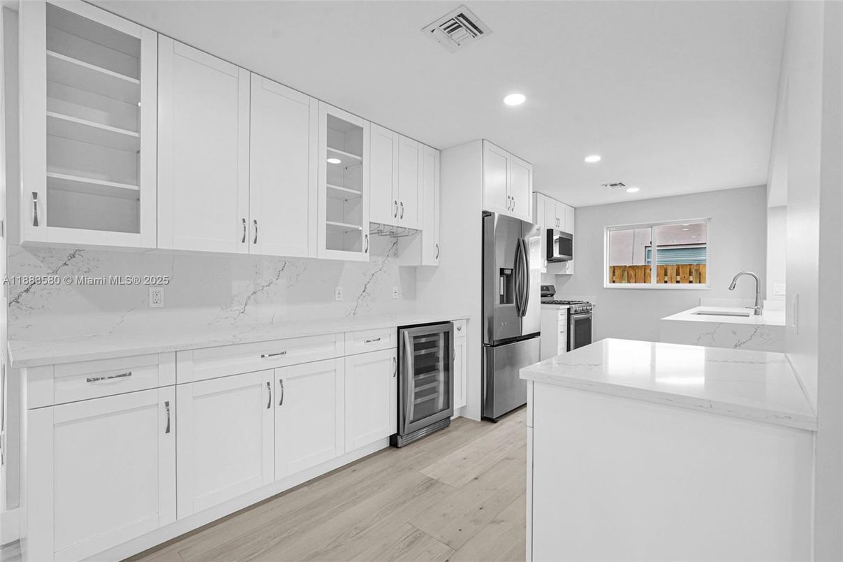 Interior, Kitchen, Marble Walls, Recessed Lighting, Stainless Steel Appliances, Wood Texture Flooring