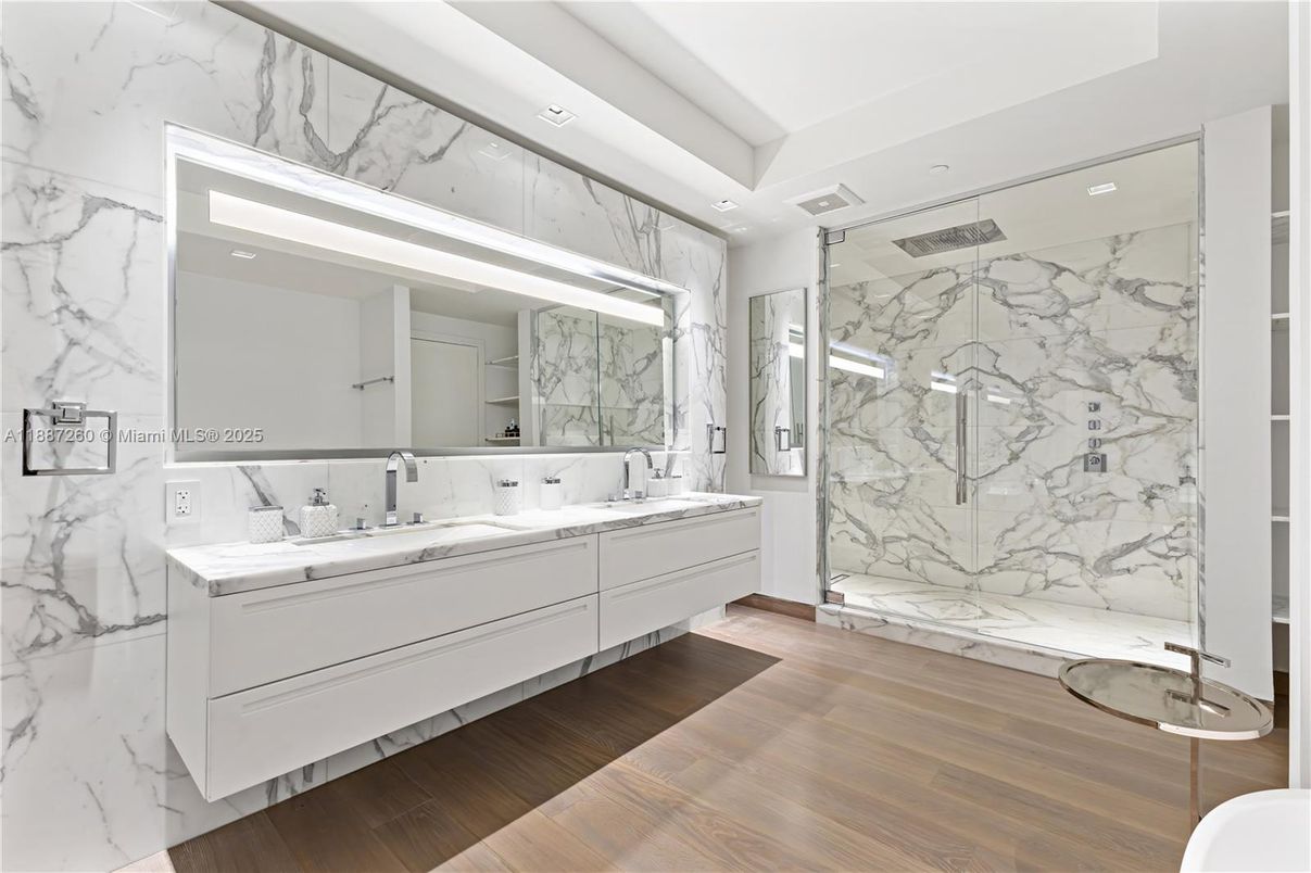 Bathroom, Dual Sink Vanities, Glass Shower, Interior, Marble Walls, Recessed Lighting, Wood Texture Flooring