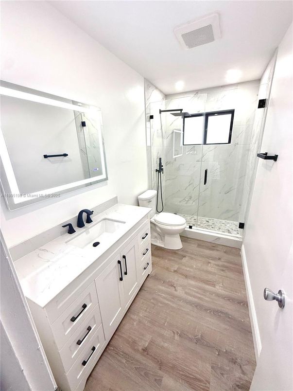 Bathroom, Dual Sink Vanities, Glass Shower, Interior, Marble Walls, Recessed Lighting, Wood Texture Flooring