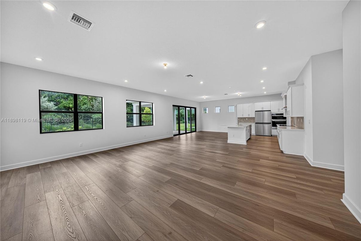 Empty room, Interior, Kitchen, Recessed Lighting, Stainless Steel Appliances, Wood Texture Flooring