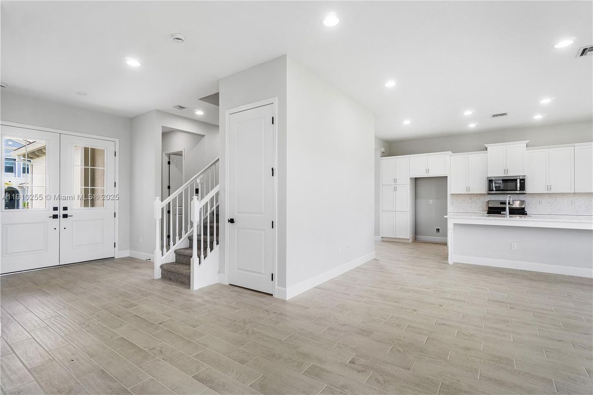 Empty room, Interior, Kitchen, Recessed Lighting, Stainless Steel Appliances, Wood Texture Flooring