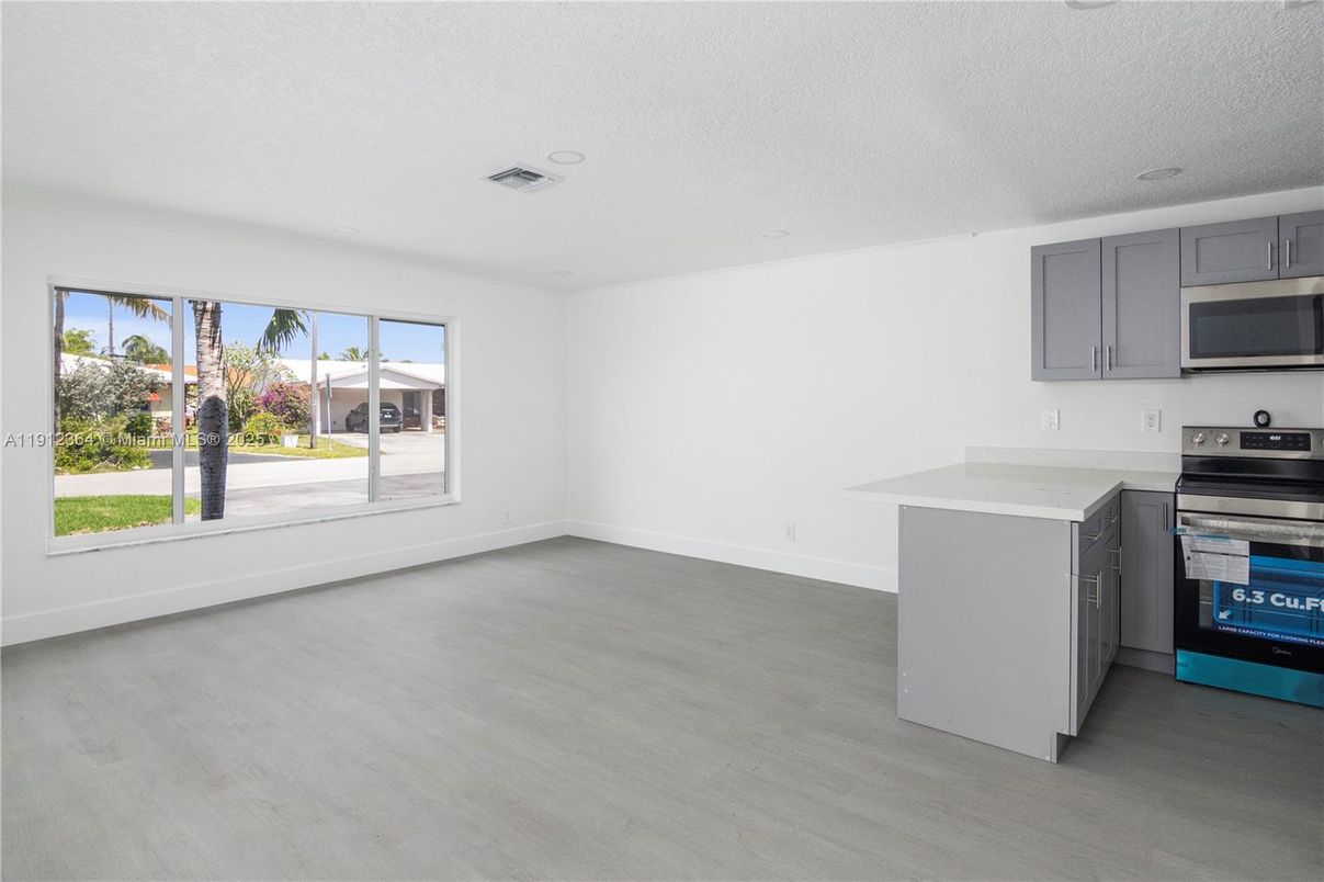 Empty room, Interior, Kitchen, Recessed Lighting, Stainless Steel Appliances, Wood Texture Flooring
