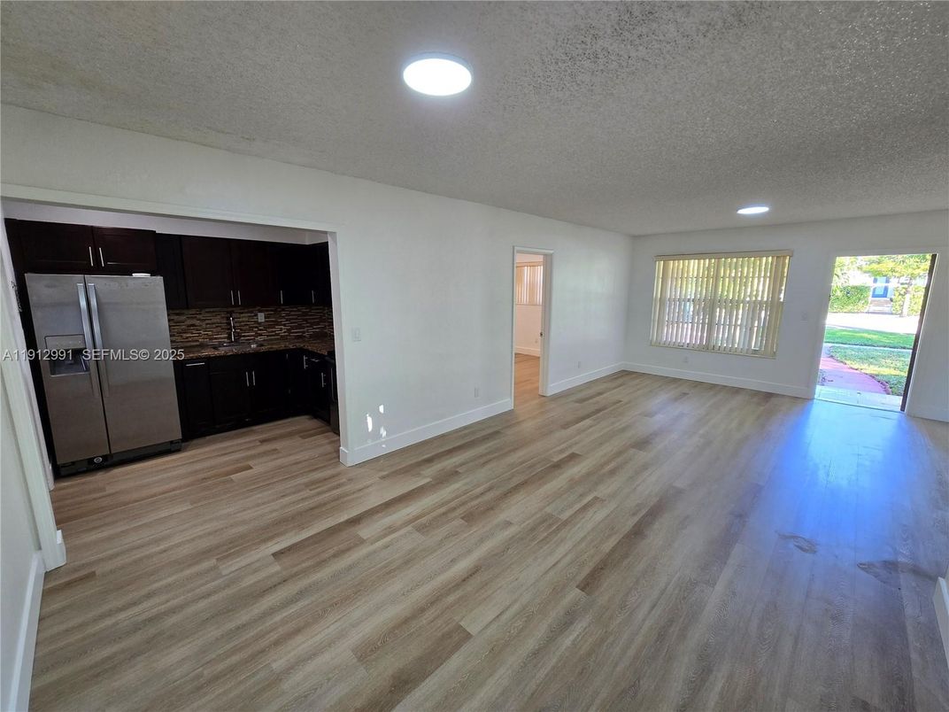 Empty room, Interior, Kitchen, Recessed Lighting, Stainless Steel Appliances, Wood Texture Flooring