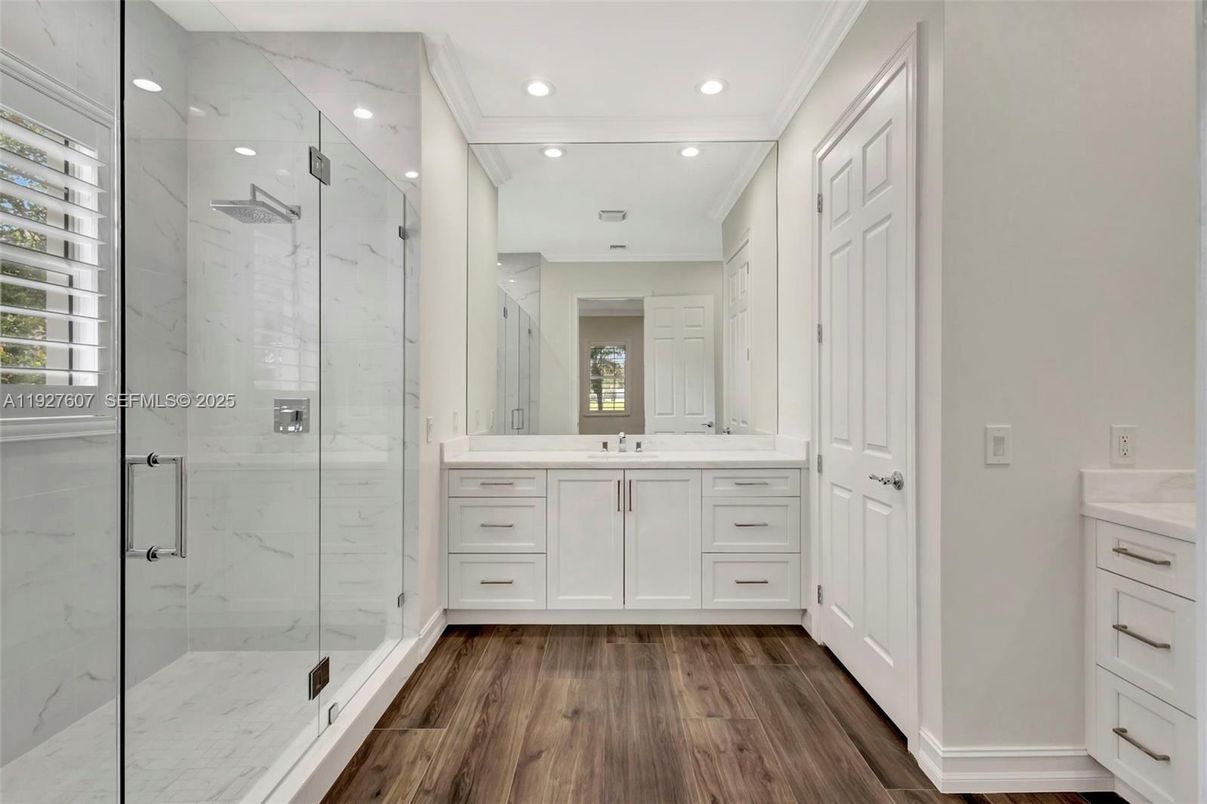 Bathroom, Dual Sink Vanities, Glass Shower, Interior, Marble Walls, Recessed Lighting, Wood Texture Flooring