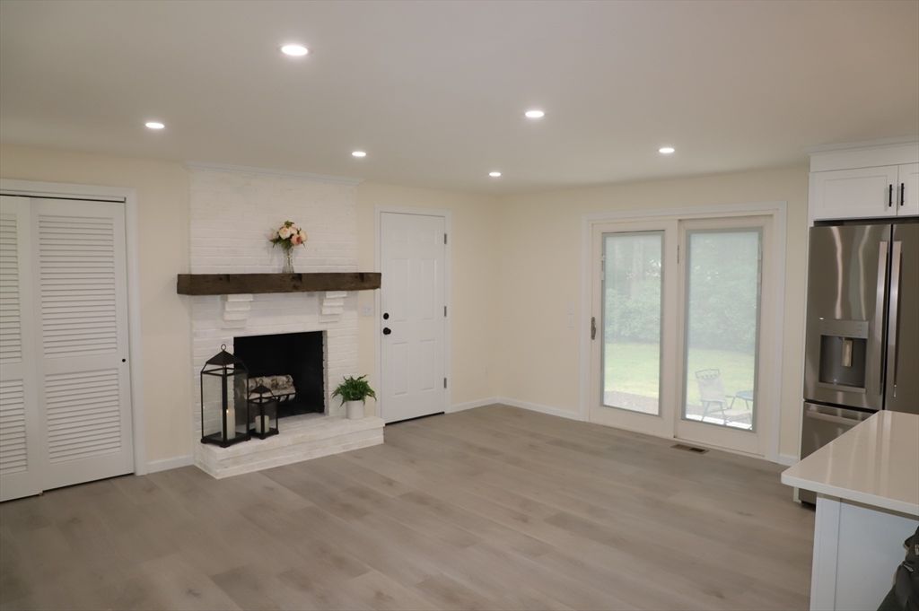 Empty room, Fireplace, Interior, Kitchen, Recessed Lighting, Stainless Steel Appliances, Wood Texture Flooring