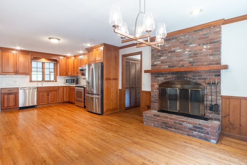 Fireplace, Interior, Kitchen, Pendant Lights, Recessed Lighting, Stainless Steel Appliances, Stone Walls, Wood Texture Flooring