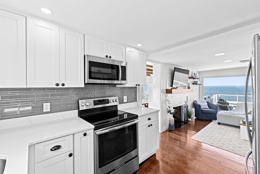 Fireplace, Interior, Kitchen, Living room, Recessed Lighting, Stainless Steel Appliances, Water, Wood Texture Flooring