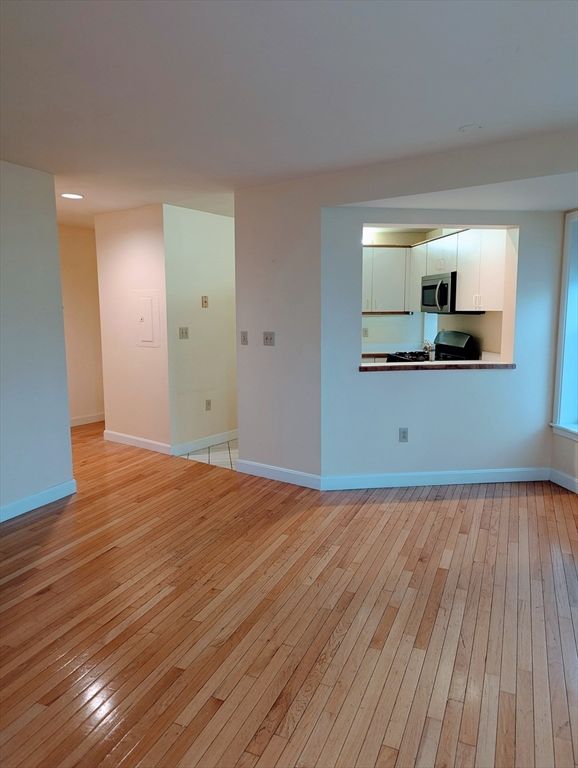 Empty room, Interior, Kitchen, Recessed Lighting, Stainless Steel Appliances, Wood Texture Flooring