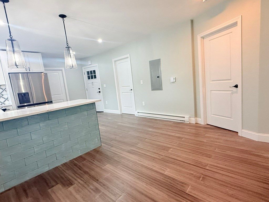 Empty room, Interior, Kitchen, Pendant Lights, Recessed Lighting, Stainless Steel Appliances, Wood Texture Flooring