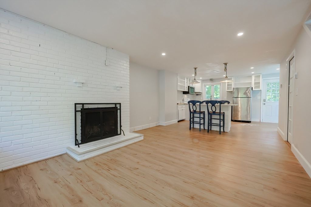 Empty room, Fireplace, Interior, Kitchen, Pendant Lights, Recessed Lighting, Stainless Steel Appliances, Stone Walls, Wood Texture Flooring