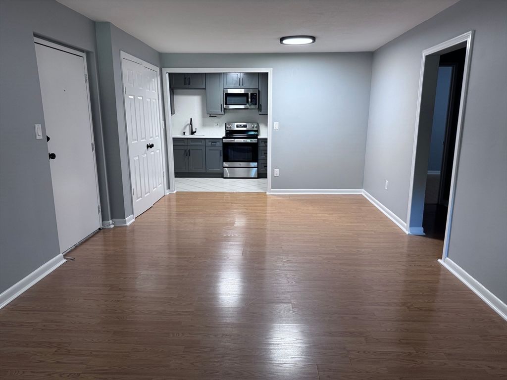 Empty room, Interior, Kitchen, Recessed Lighting, Stainless Steel Appliances, Wood Texture Flooring