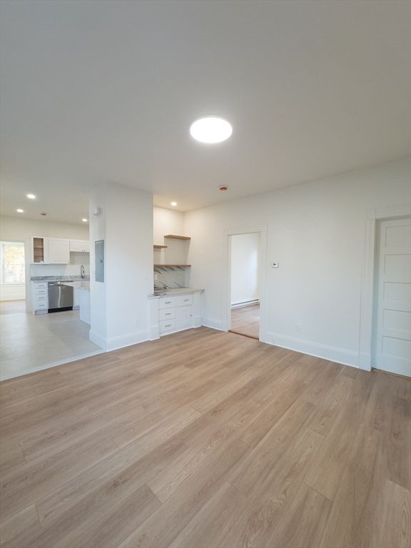 Empty room, Interior, Kitchen, Recessed Lighting, Stainless Steel Appliances, Wood Texture Flooring