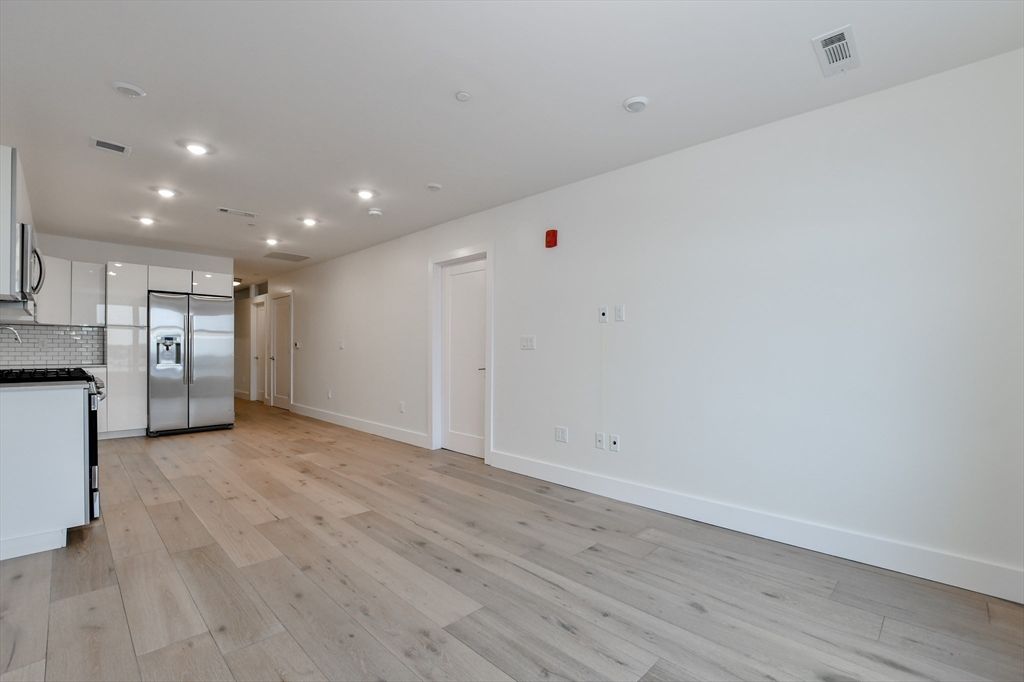 Empty room, Interior, Kitchen, Recessed Lighting, Stainless Steel Appliances, Wood Texture Flooring