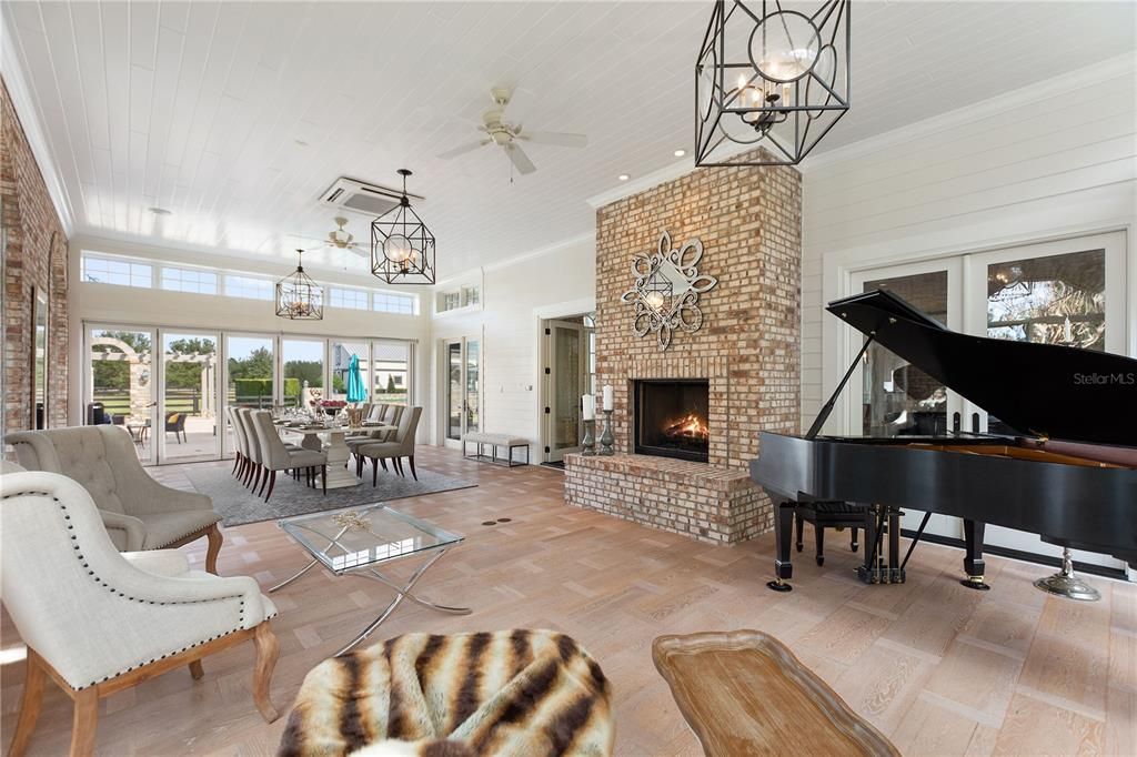 Chandelier, Dining room, Fireplace, Interior, Pendant Lights, Piano, Recessed Lighting, Stone Walls, Wood Texture Flooring