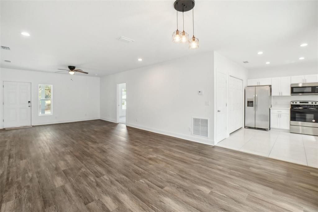 Empty room, Interior, Kitchen, Pendant Lights, Recessed Lighting, Stainless Steel Appliances, Wood Texture Flooring