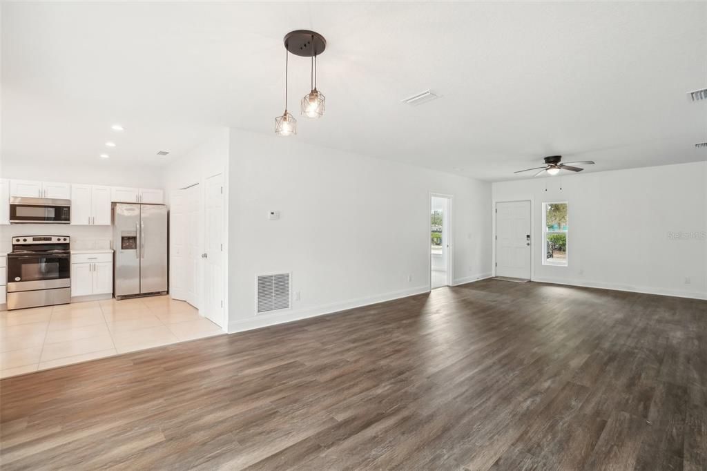Empty room, Interior, Kitchen, Pendant Lights, Recessed Lighting, Stainless Steel Appliances, Wood Texture Flooring