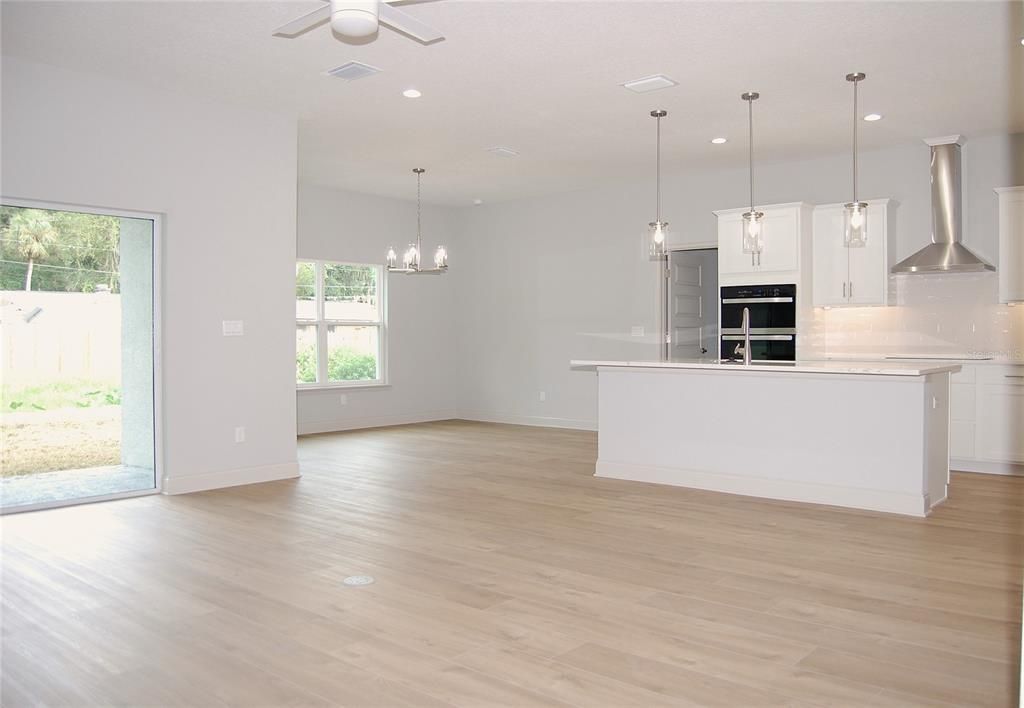 Empty room, Interior, Kitchen, Pendant Lights, Recessed Lighting, Stainless Steel Appliances, Wood Texture Flooring