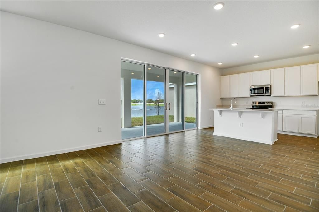 Empty room, Interior, Kitchen, Recessed Lighting, Stainless Steel Appliances, Water, Wood Texture Flooring