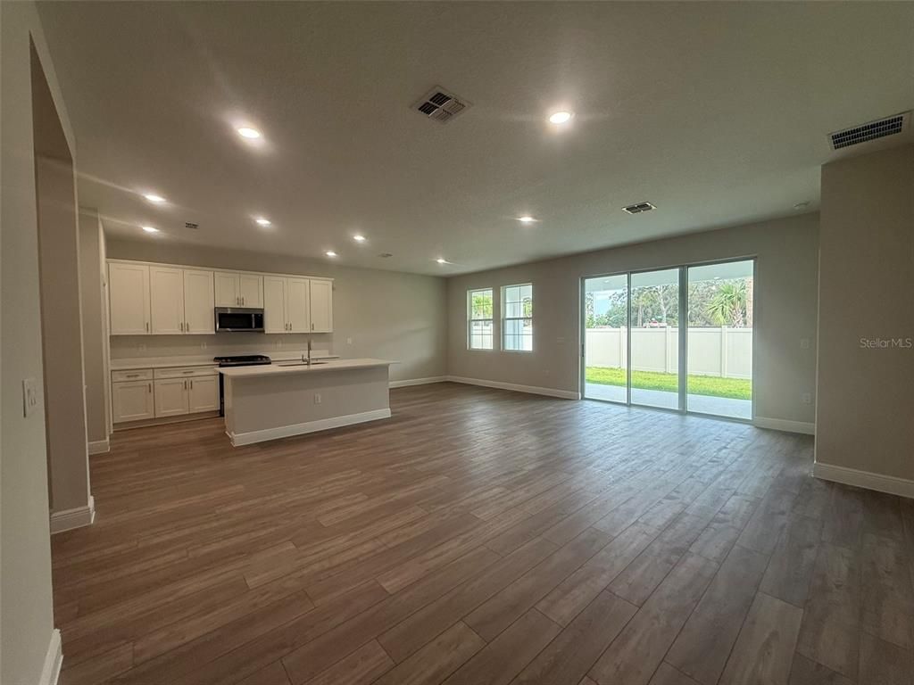 Empty room, Interior, Kitchen, Recessed Lighting, Stainless Steel Appliances, Wood Texture Flooring