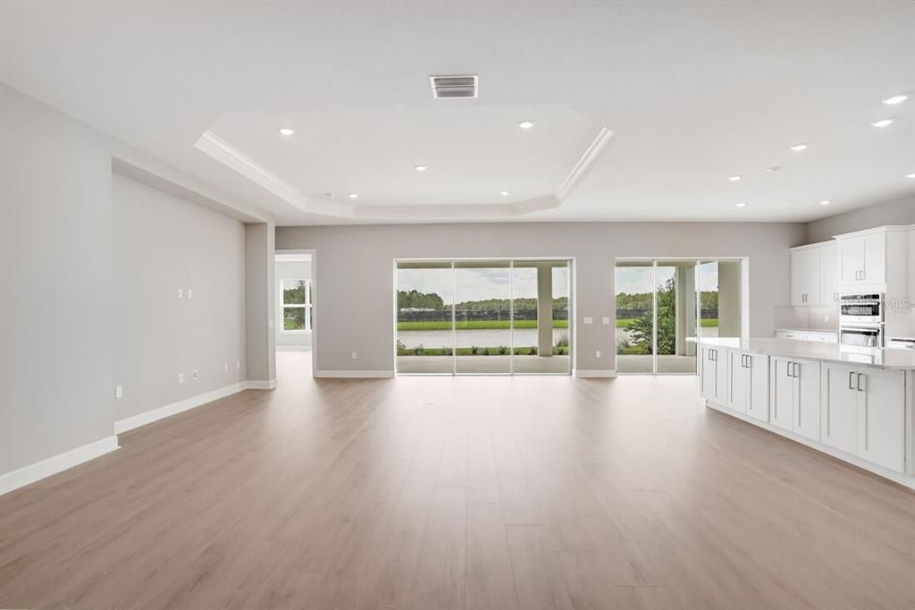 Empty room, Interior, Kitchen, Recessed Lighting, Stainless Steel Appliances, Wood Texture Flooring