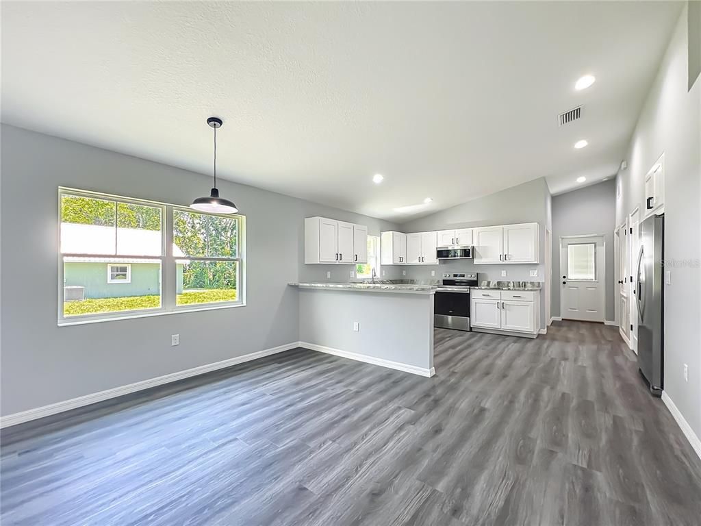 Empty room, Interior, Kitchen, Pendant Lights, Recessed Lighting, Stainless Steel Appliances, Wood Texture Flooring