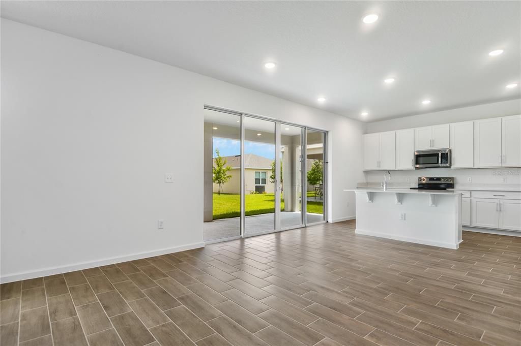 Empty room, Interior, Kitchen, Recessed Lighting, Stainless Steel Appliances, Wood Texture Flooring