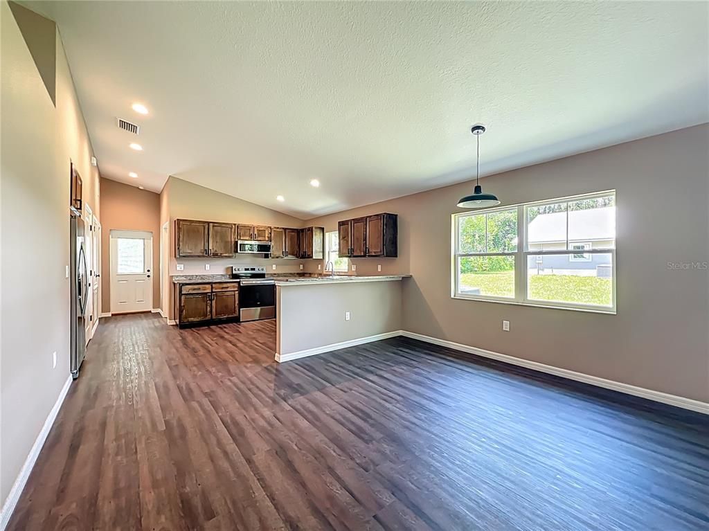 Empty room, Interior, Kitchen, Pendant Lights, Recessed Lighting, Stainless Steel Appliances, Wood Texture Flooring