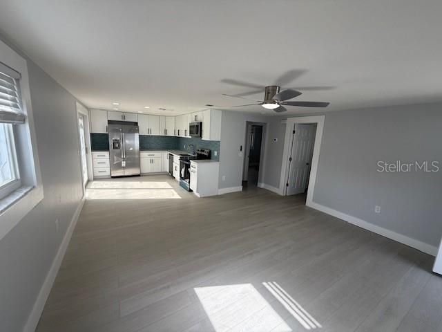 Empty room, Interior, Kitchen, Recessed Lighting, Stainless Steel Appliances, Wood Texture Flooring
