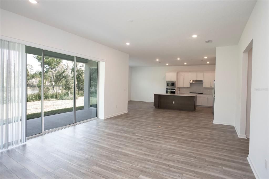 Empty room, Interior, Kitchen, Recessed Lighting, Stainless Steel Appliances, Wood Texture Flooring