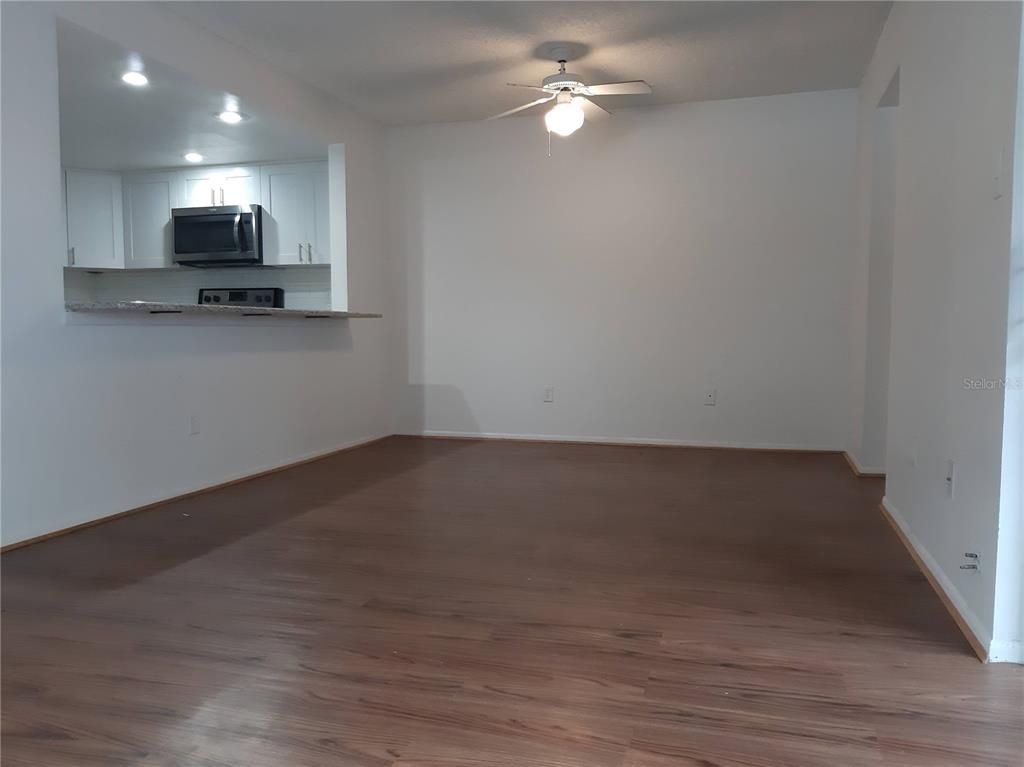 Empty room, Interior, Kitchen, Recessed Lighting, Stainless Steel Appliances, Wood Texture Flooring