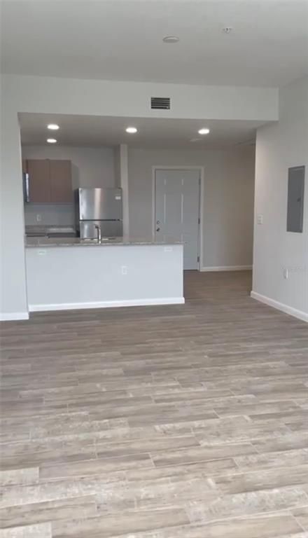 Empty room, Interior, Kitchen, Recessed Lighting, Stainless Steel Appliances, Wood Texture Flooring
