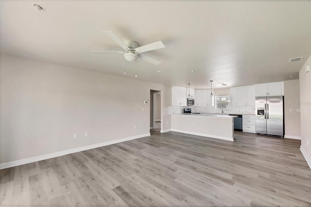 Empty room, Interior, Kitchen, Recessed Lighting, Stainless Steel Appliances, Wood Texture Flooring