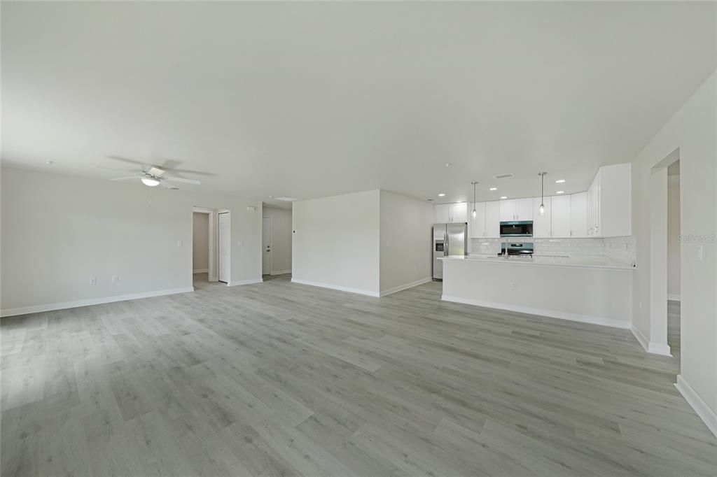 Empty room, Interior, Kitchen, Recessed Lighting, Stainless Steel Appliances, Wood Texture Flooring