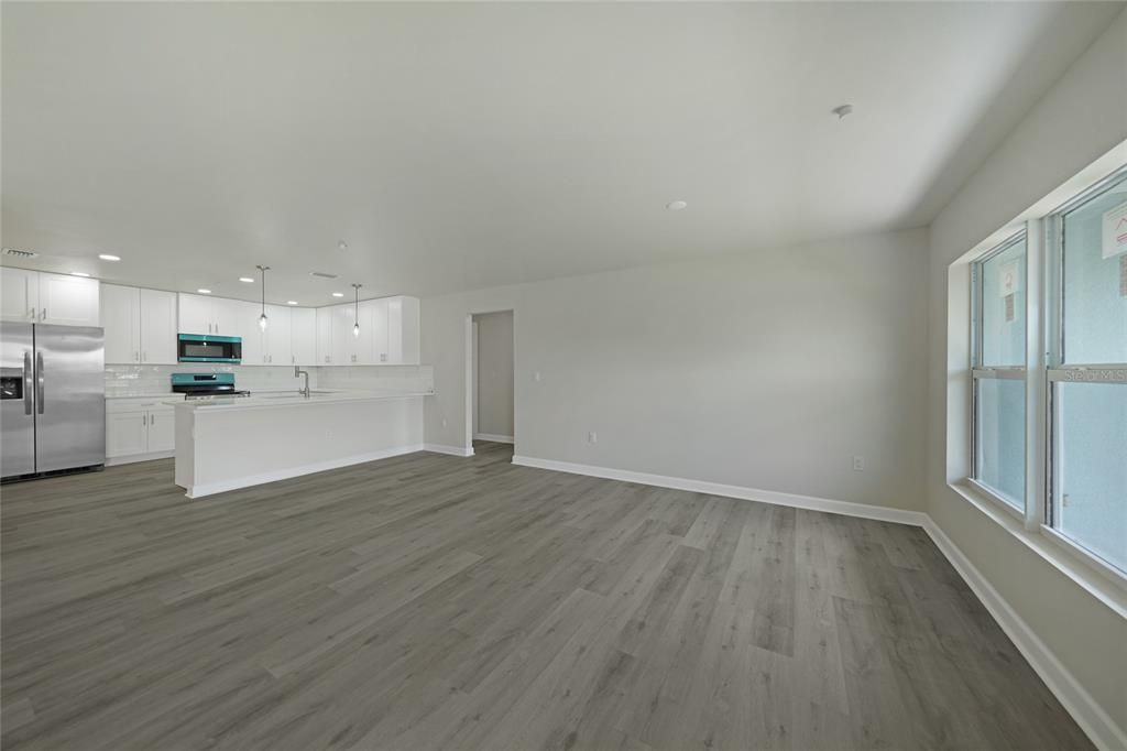 Empty room, Interior, Kitchen, Pendant Lights, Recessed Lighting, Stainless Steel Appliances, Wood Texture Flooring