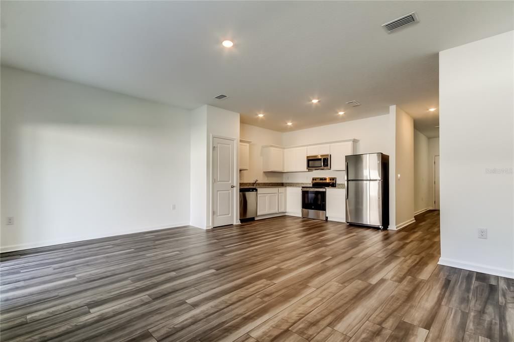 Empty room, Interior, Kitchen, Recessed Lighting, Stainless Steel Appliances, Wood Texture Flooring