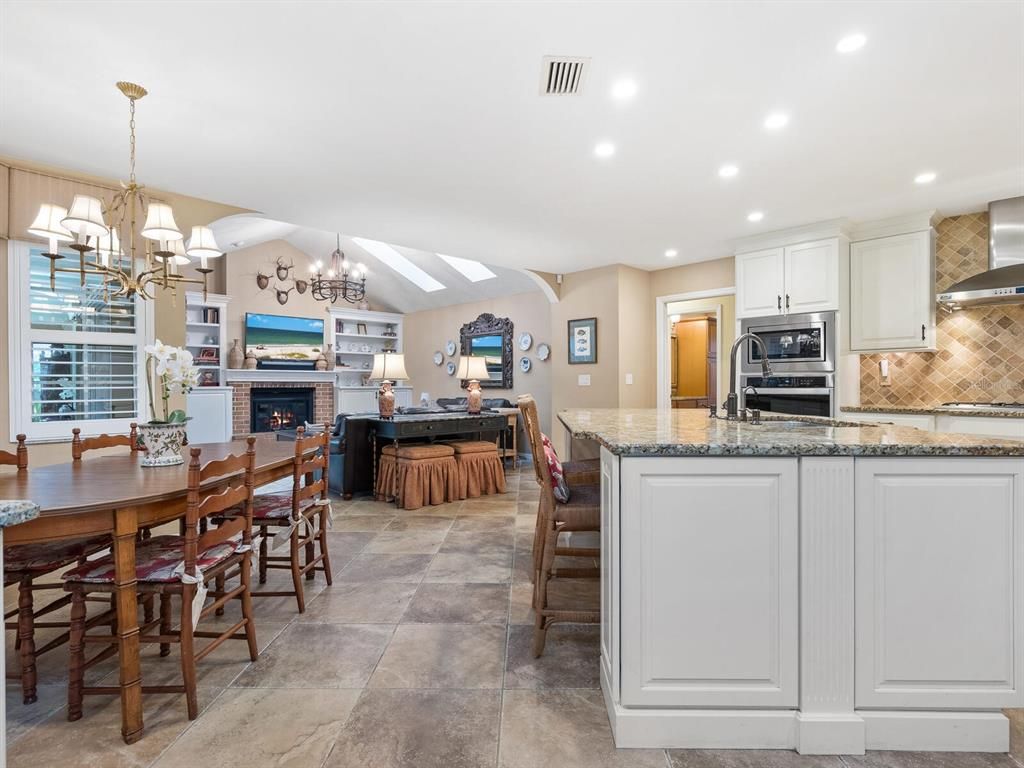 Chandelier, Dining room, Fireplace, Interior, Kitchen, Living room, Recessed Lighting, Stainless Steel Appliances