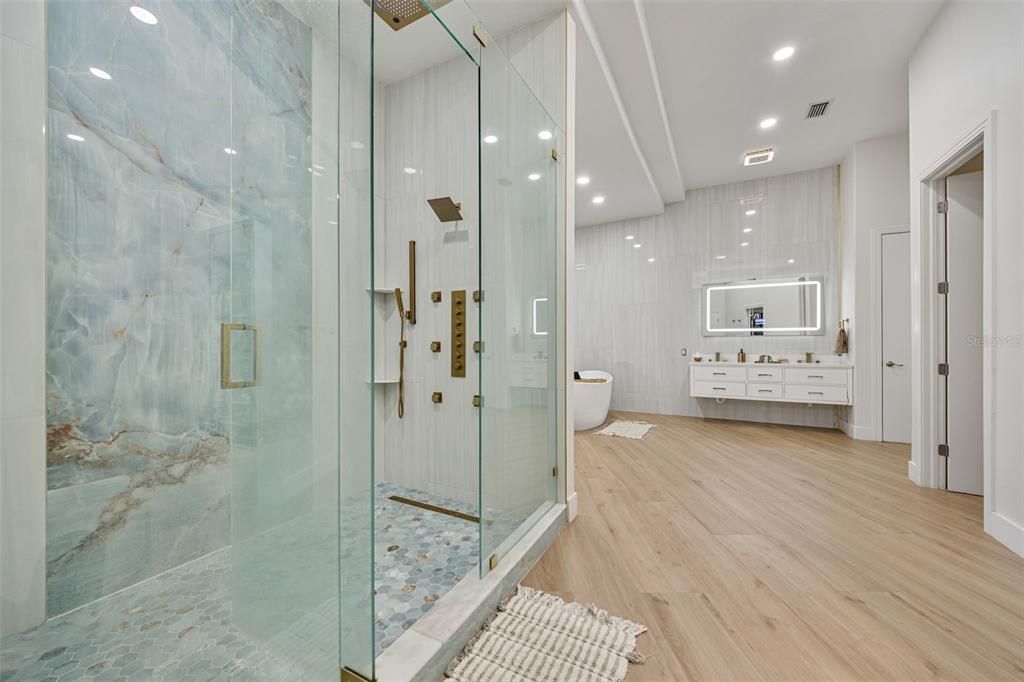 Bathroom, Free Standing Baths, Glass Shower, Interior, Marble Walls, Recessed Lighting, Wood Texture Flooring