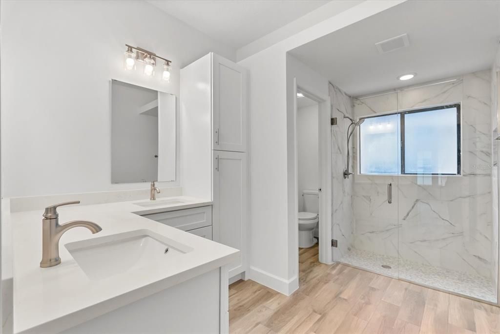 Bathroom, Dual Sink Vanities, Glass Shower, Interior, Marble Walls, Recessed Lighting, Wood Texture Flooring
