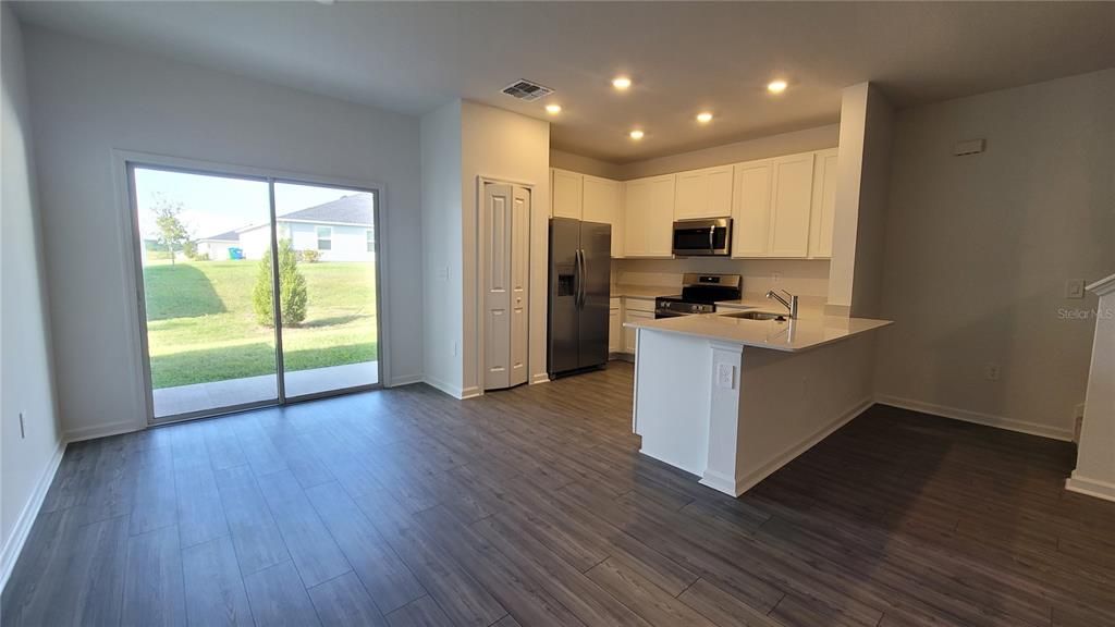 Empty room, Interior, Kitchen, Recessed Lighting, Stainless Steel Appliances, Wood Texture Flooring