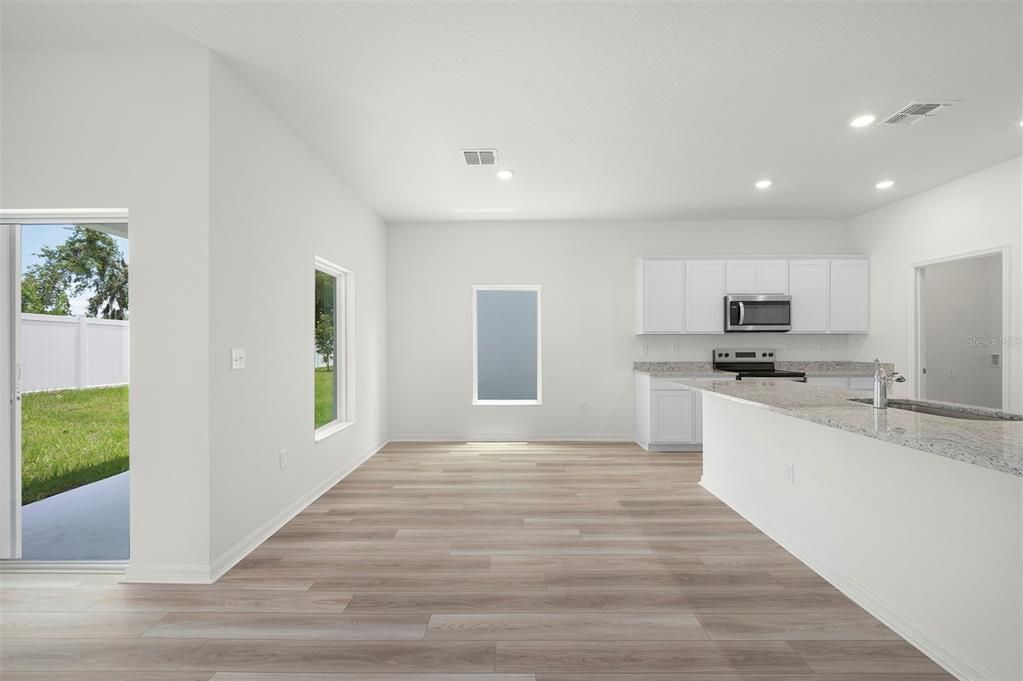 Empty room, Interior, Kitchen, Recessed Lighting, Stainless Steel Appliances, Wood Texture Flooring